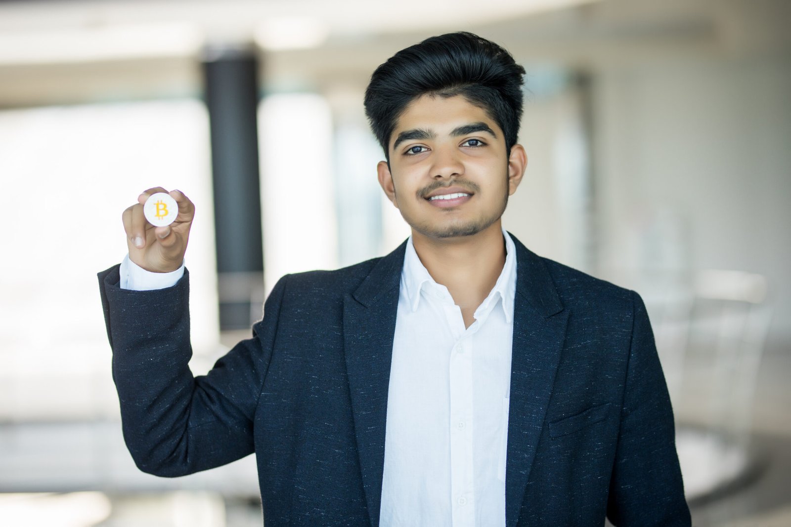 Home indian business man in suit with golden bitcoin in modern office
